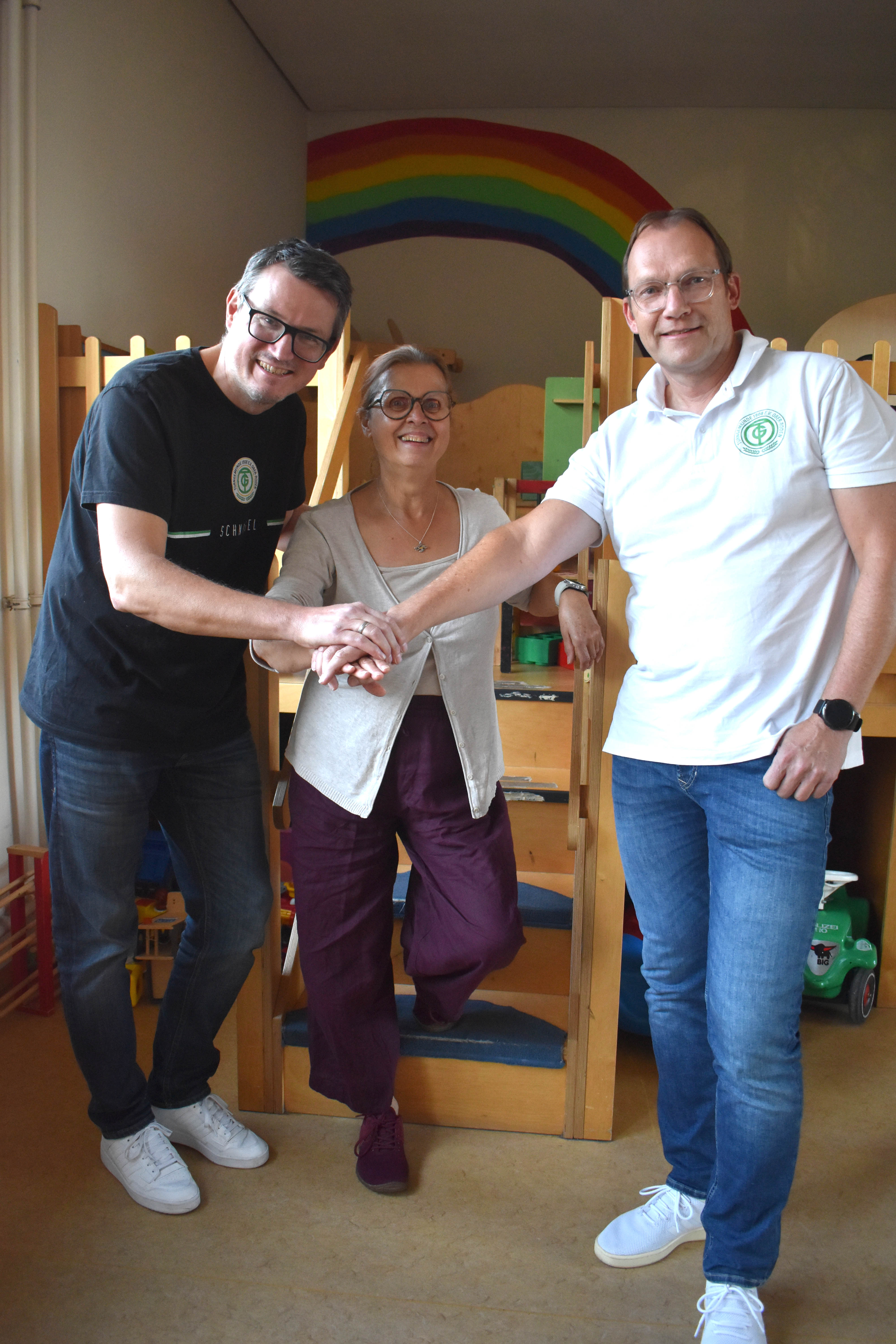 Unterm verbindenden Regenbogen wurde die Nutzungsüberlassung des Gemeindesaales an die TG durch die Ev. Kirchengemeinde Rödermark mit Handschlag besiegelt (von links TG-Vorstand Stefan Hitzel, Kirchenvorstandsvorsitzende Erika Neudert und der TG-Vorsitzende Jochen Weiland)