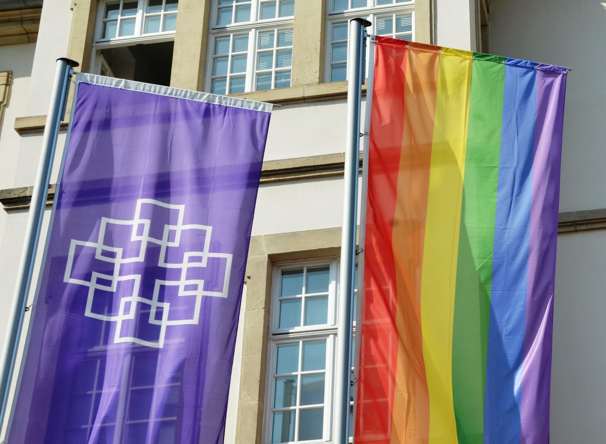 Vor der Kirchenverwaltung der EKHN wurden neben der lila EKHN-Fahne mit Facettenkreuz anlässlich des CSD auch eine Regenbogenfahne gehisst.