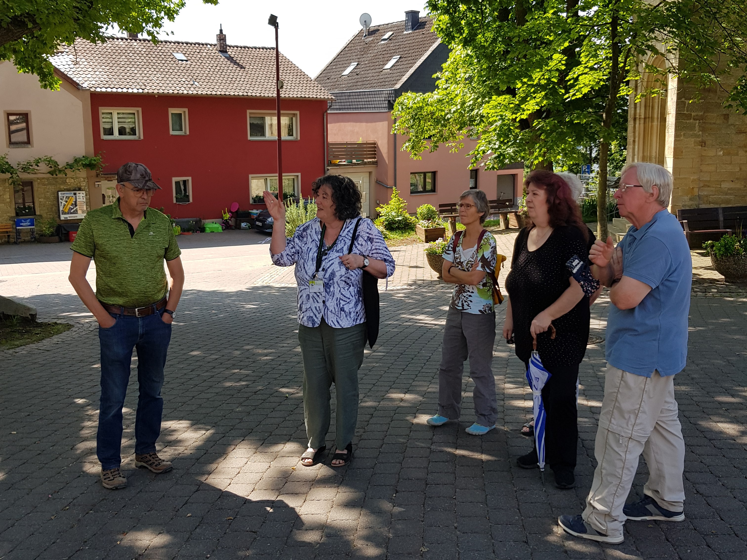 Menschen stehen zusammen vor eine Häuserzeile
