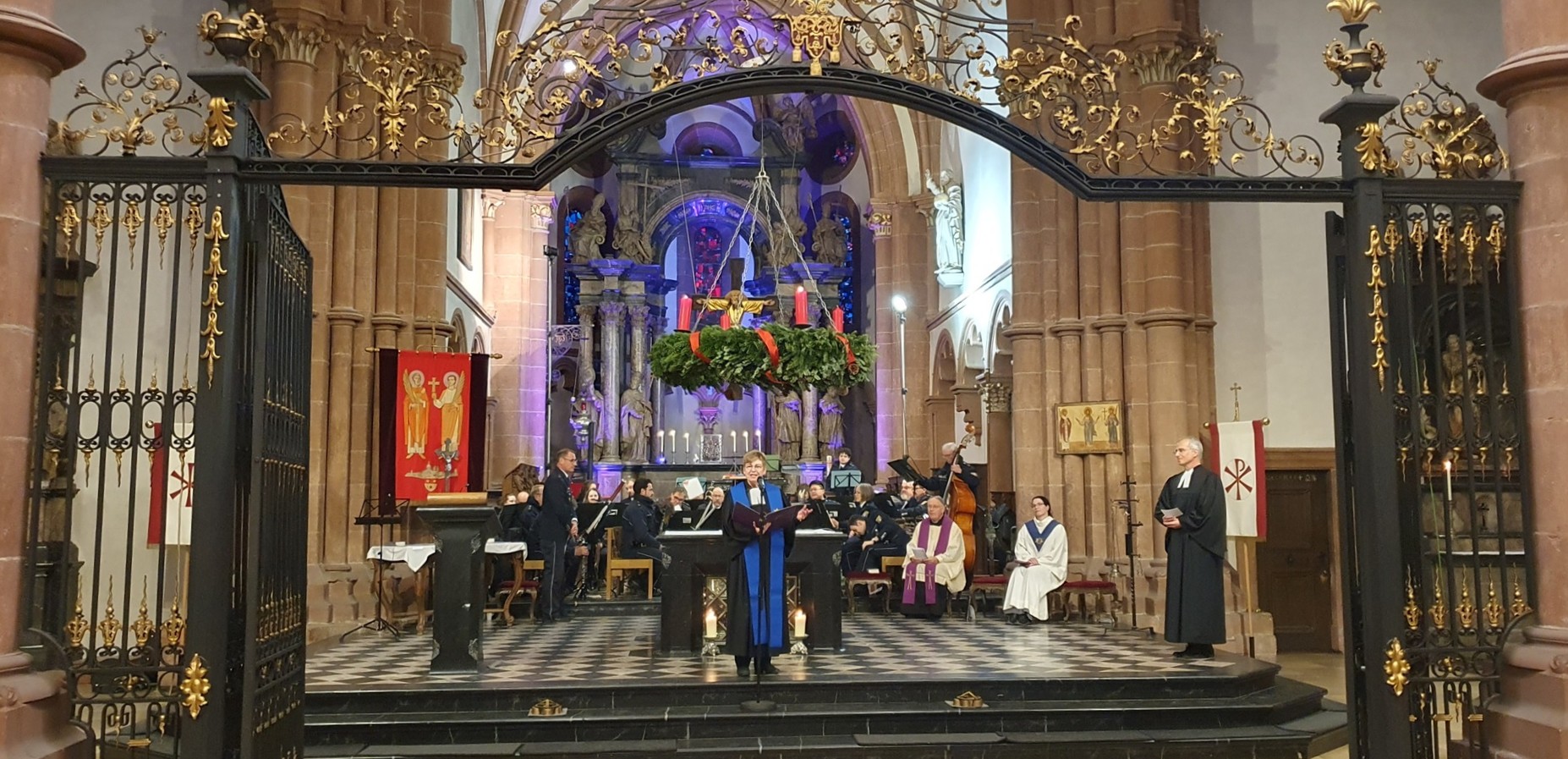 Blick in den Altarraum mit Orchester und Pfarrerin und Pfarrer