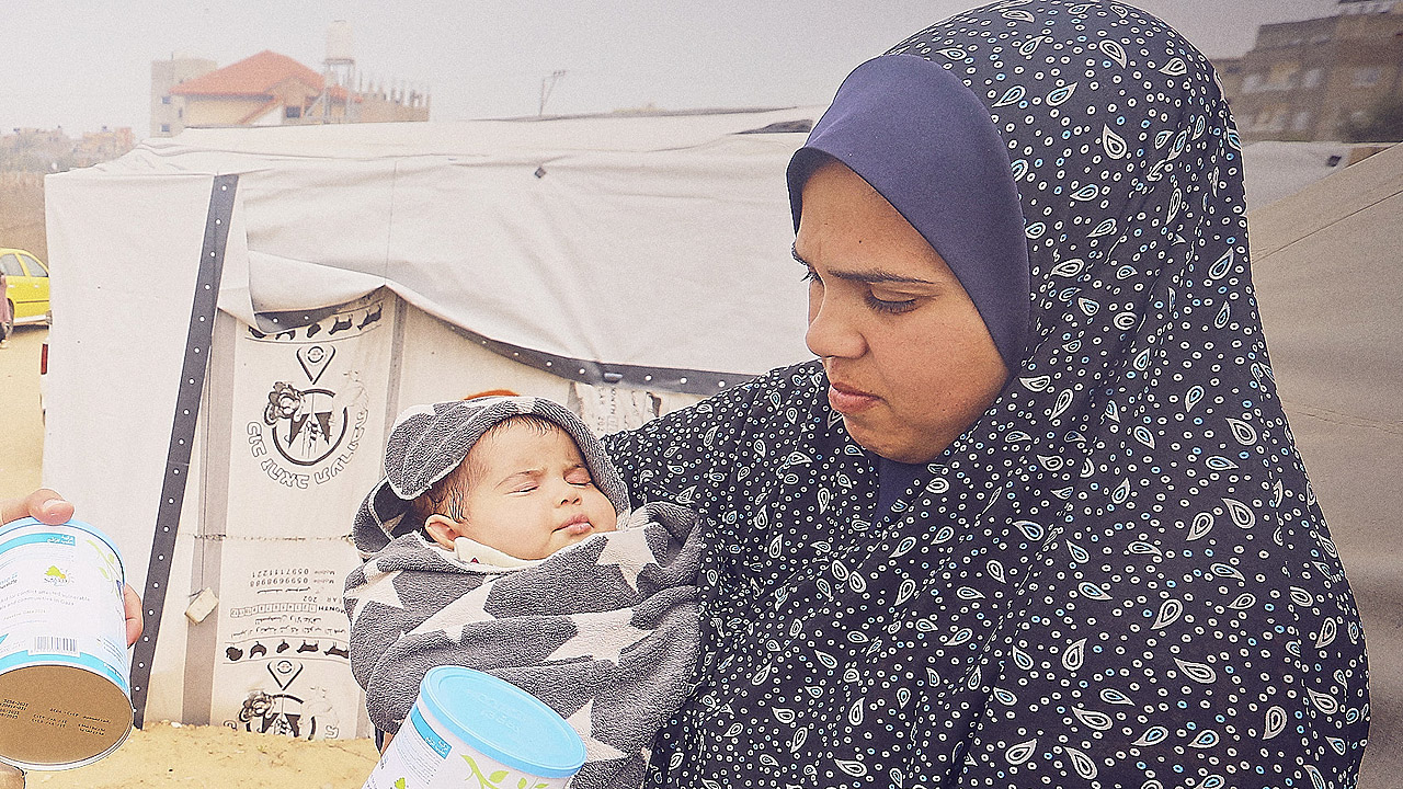 Eine Mutter mit Baby erhält Milchpulver