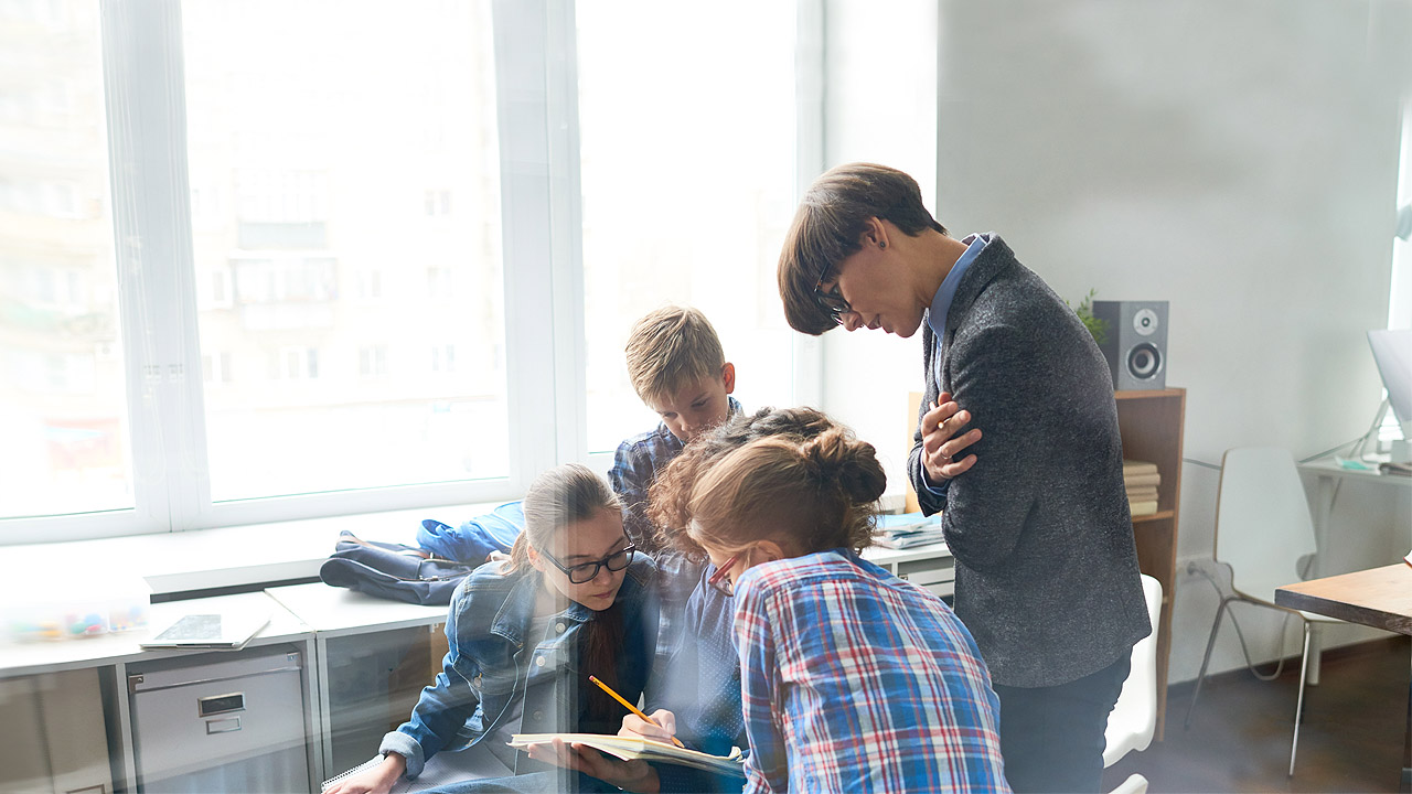 Schüler arbeiten an einem Projekt, sitzen zusammen und sprechen miteinander
