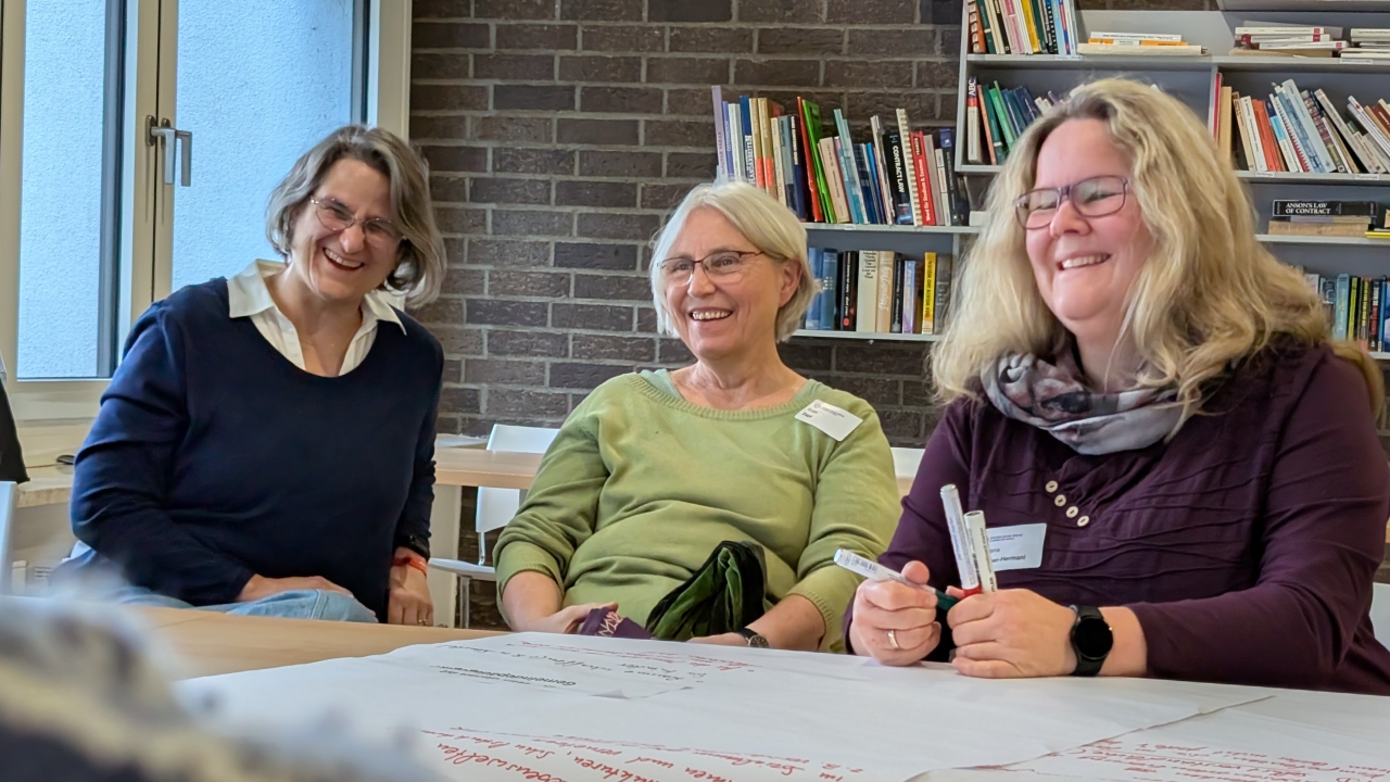 Drei Frauen sitzen beieinander mit Flipchart-Papier