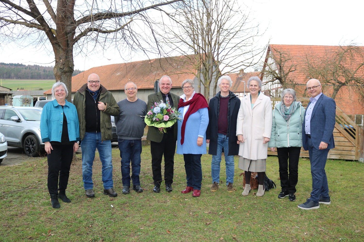 Gruppe von Menschen auf einer Wiese vor einer Kirche