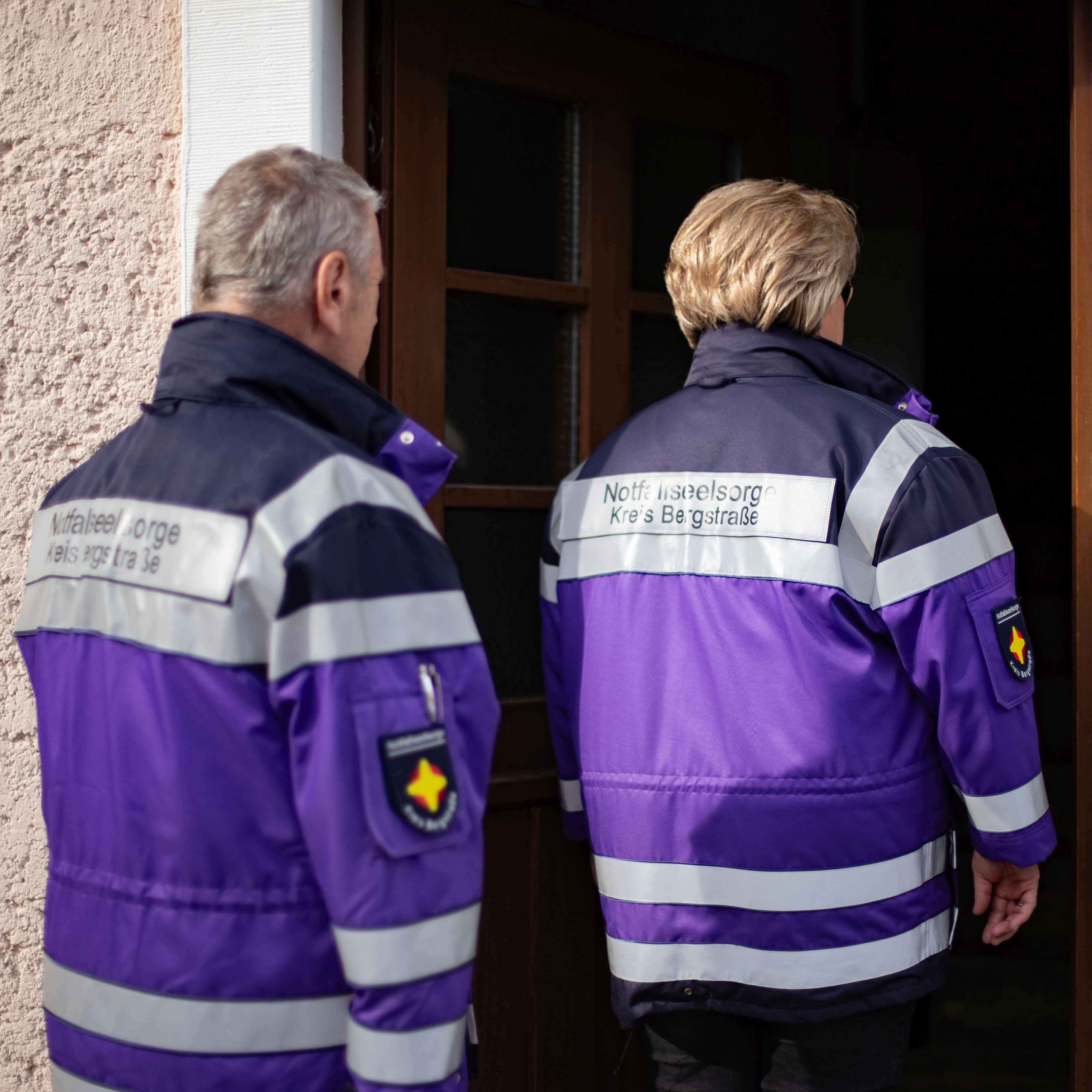 Zwei Personen der Notfallseelsorge betreten ein Haus.