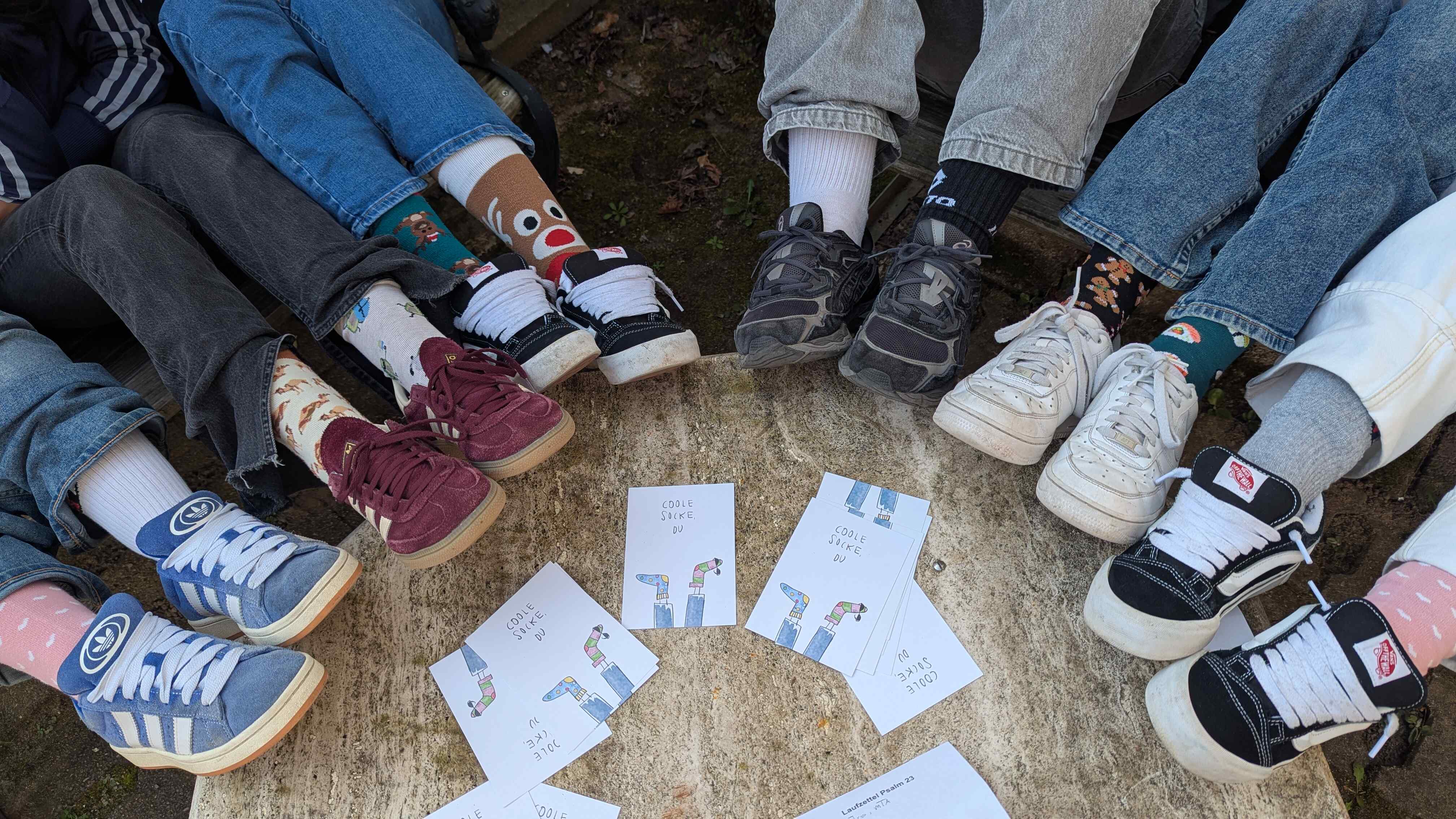 Das Bild zeigt Füße in einem Halbkreis.