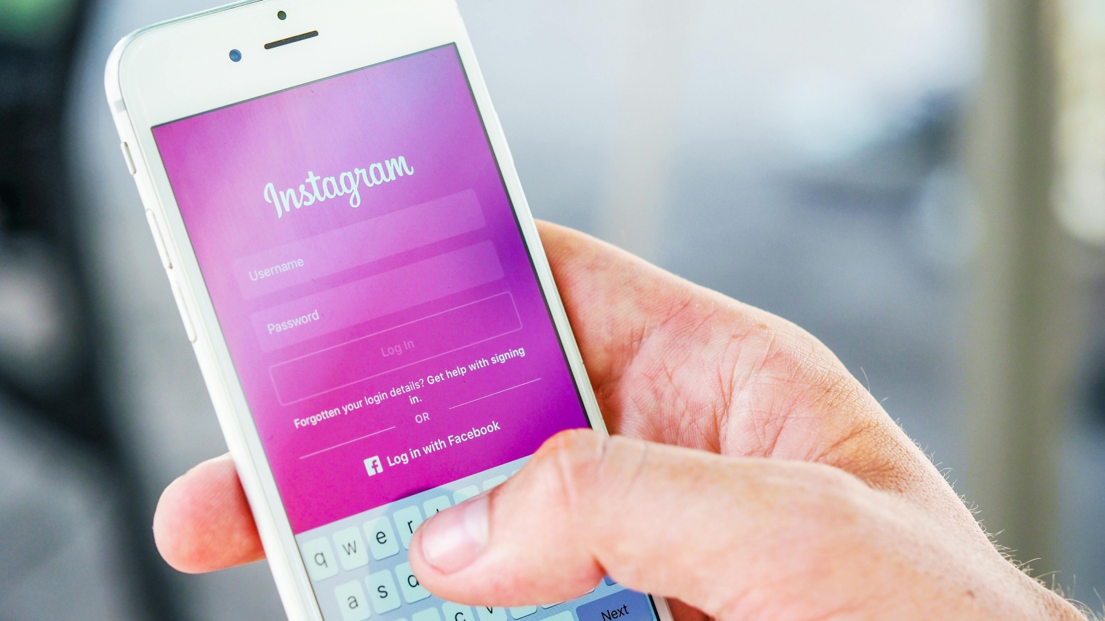 Hand mit Smartpone auf dem Instagram-Login angezeigt wird