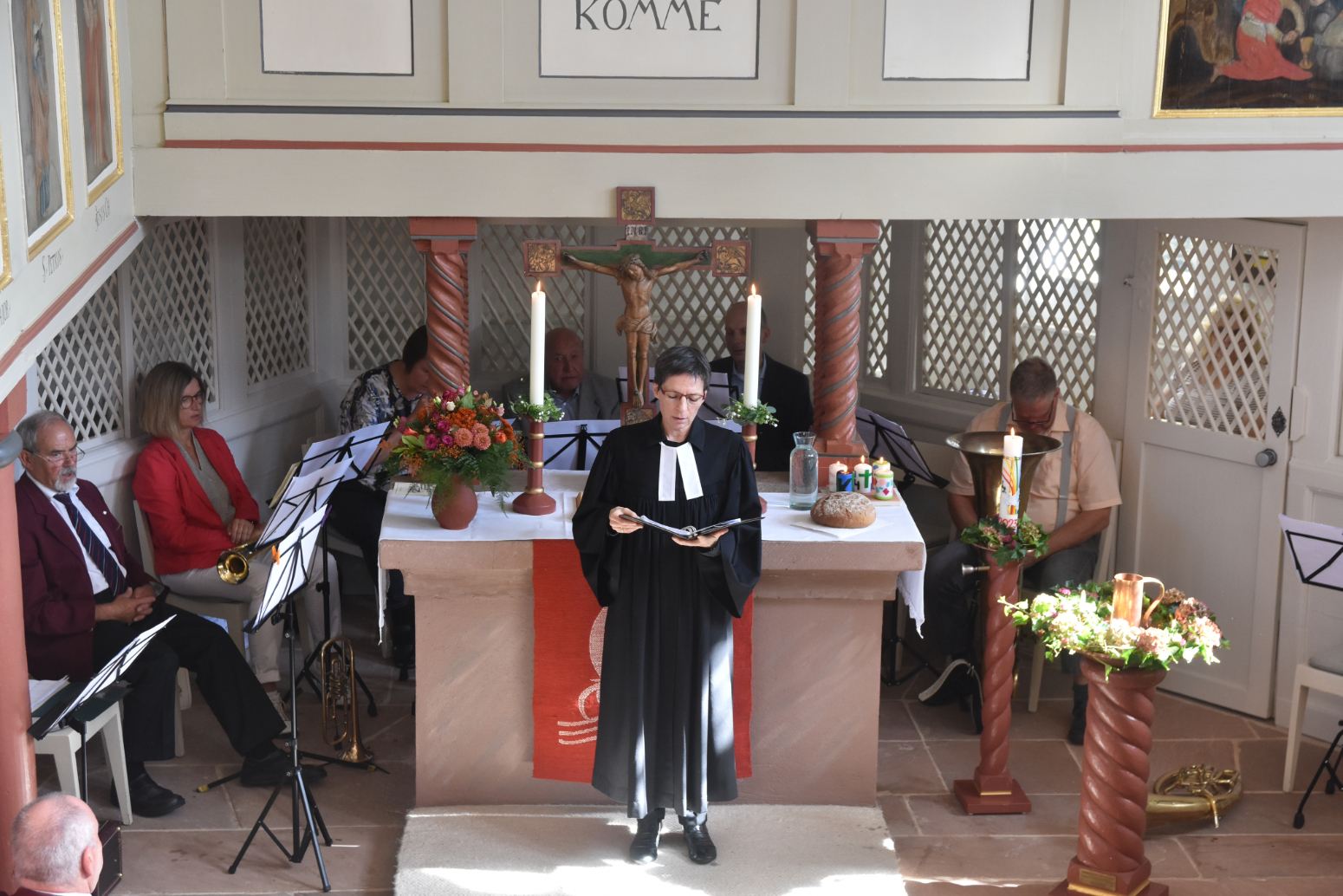 Pfarrerin Eleonore Merkel trägt einen Talar und steht während des Festgottesdienstes zum Kirchenjubiläum in Eichelsachsen im Altarraum der kleinen Fachwerkkirche.