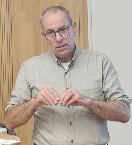 Pfarrer Christian Wiener, die Ärmel seines Hemdes hochgekrempelt, beim Vortrag im Johanniter-Saal