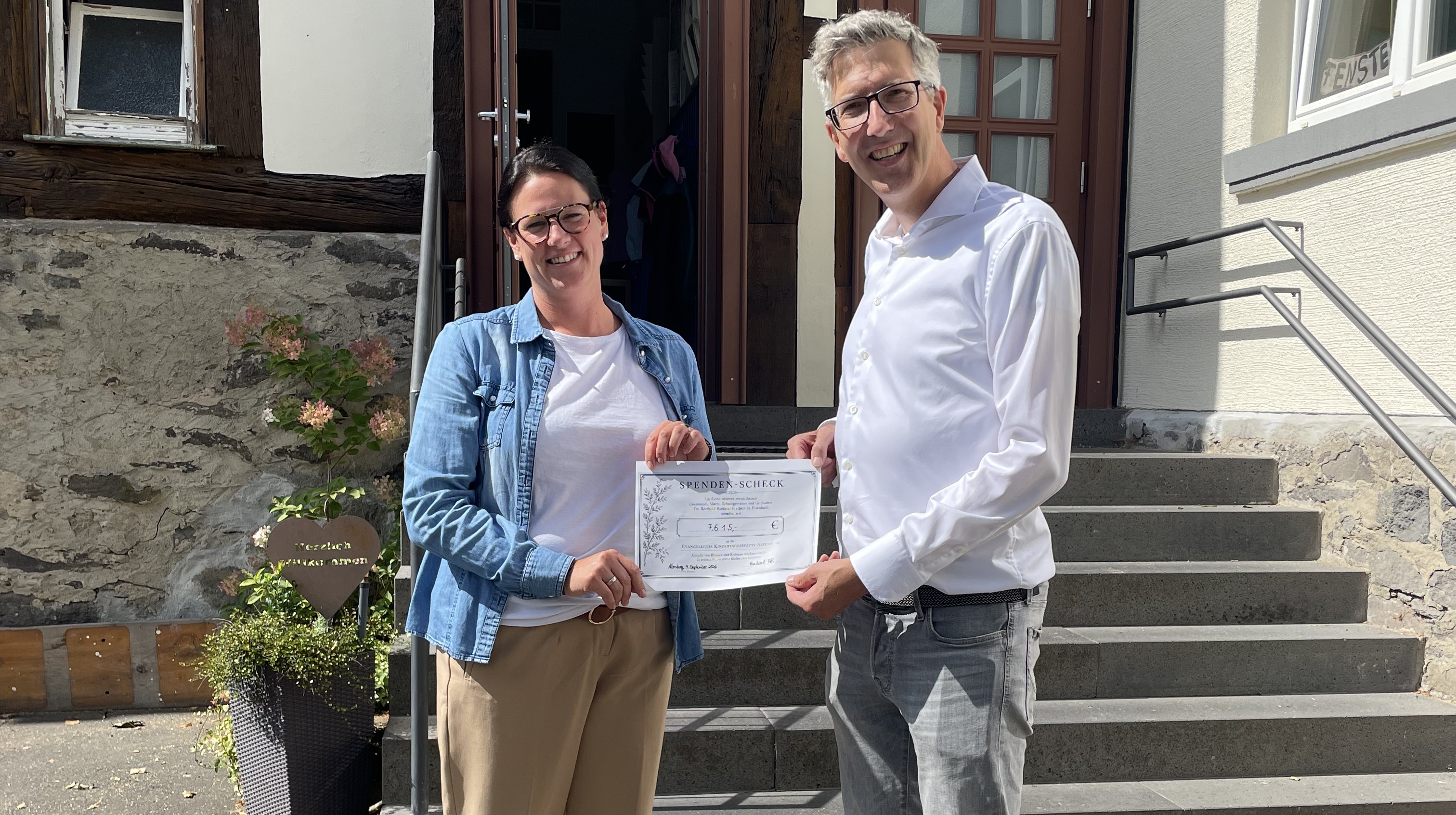 Mann und Frau mit großem Scheck