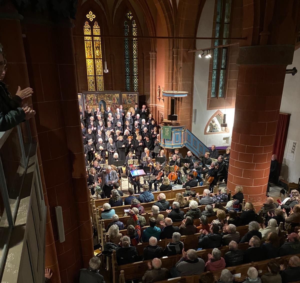 Blick in die vollbesetzte Schottener Liebfrauenkirche. Man sieht das Publikum von hinten und hat einen Blick auf den Chor im Altarraum.