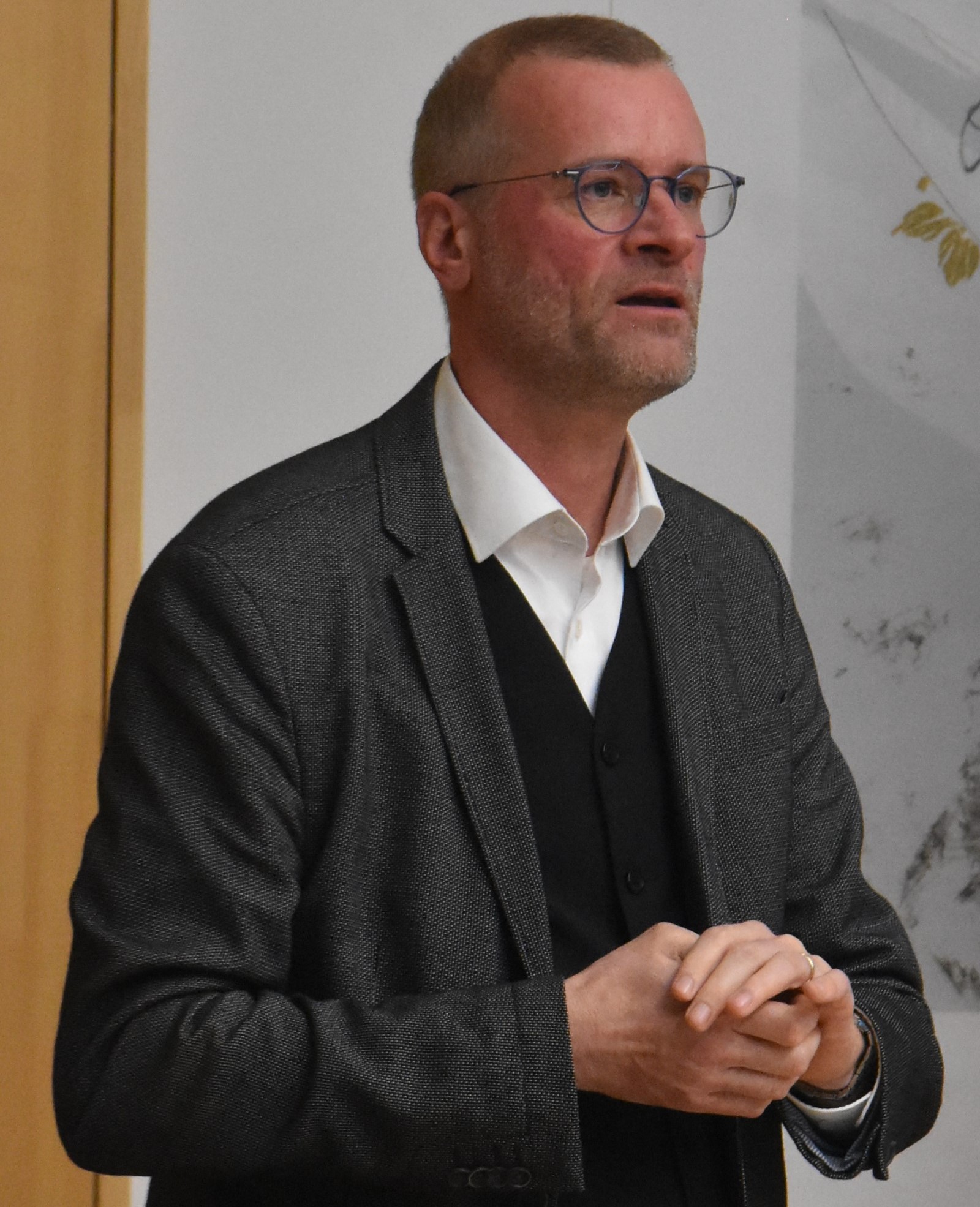 Lukas Ohly steht im Johannitersaal und hält seinen Vortrag.
