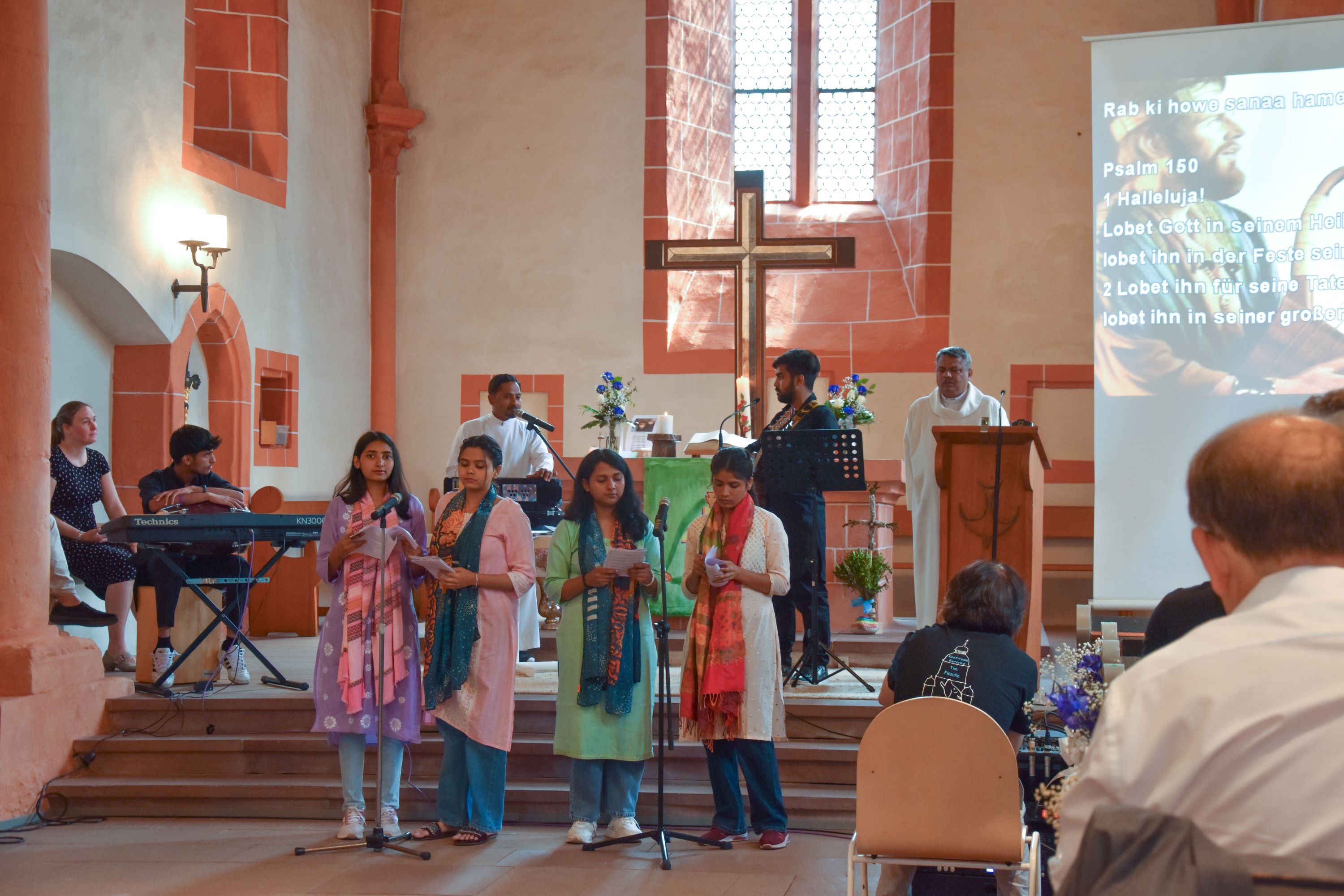 Indische Jugendliche und Erwachsene bei einem Gottesdienst in der Berstädter Kirche.