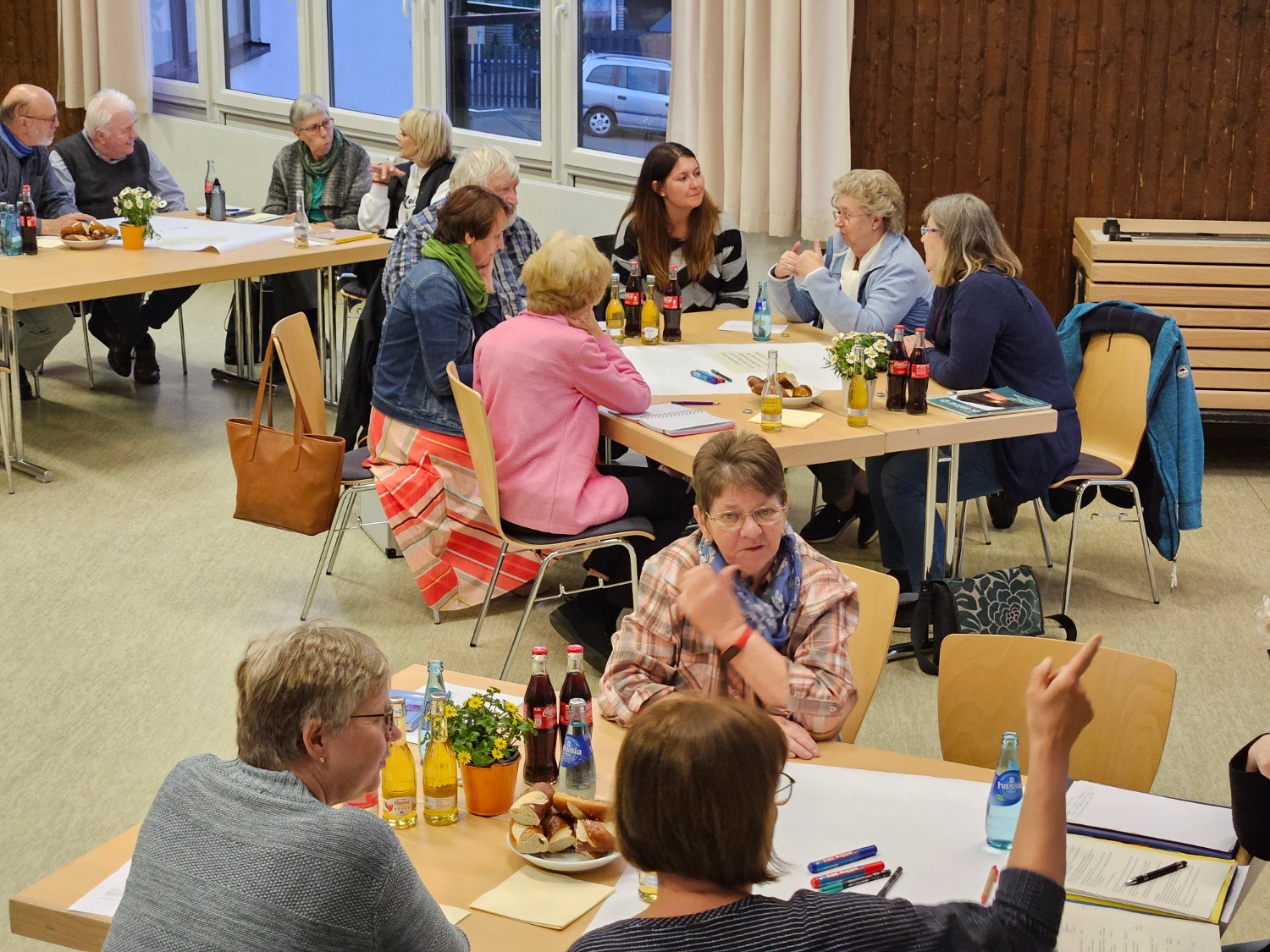 Blick in den Saal des Dporfgemeinschaftshauses Wallernhausen. An Tischgruppen sitzen Frauen und Männer, vor sich Stifte und große Plakate, die sie mit Ideen und Gedanken beschriftet haben.