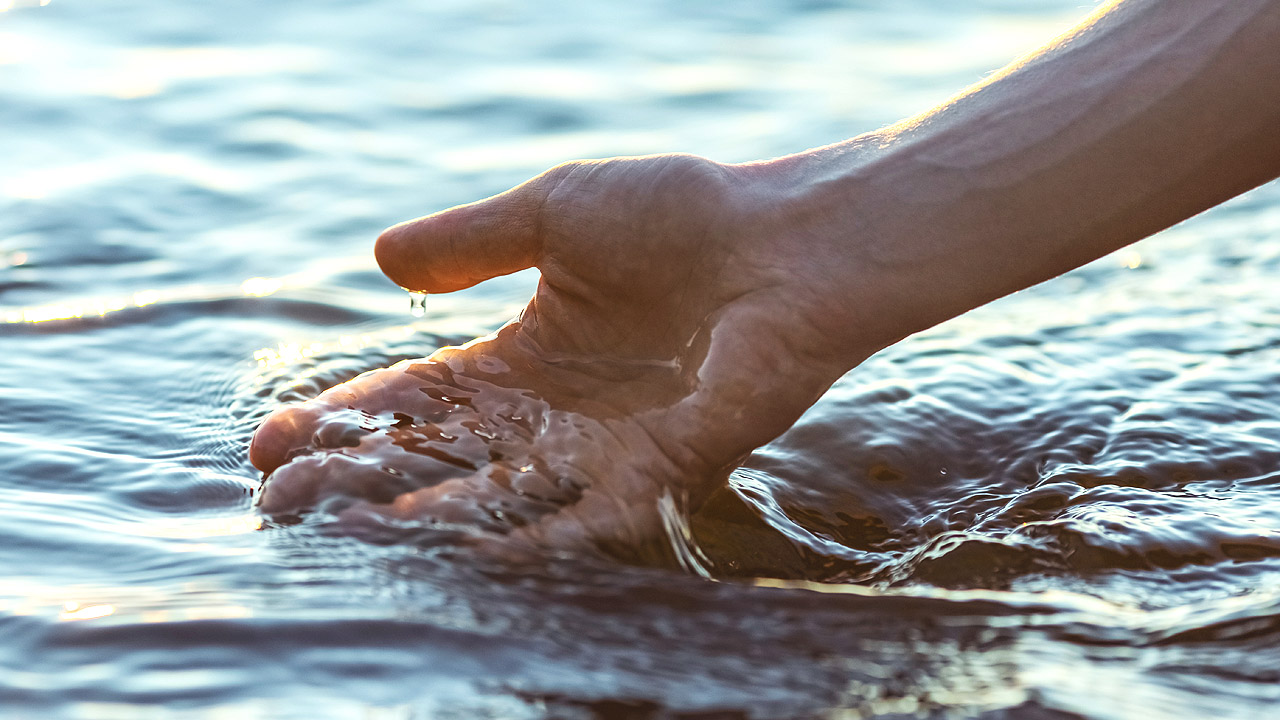 Hand, die Wasser schöpft