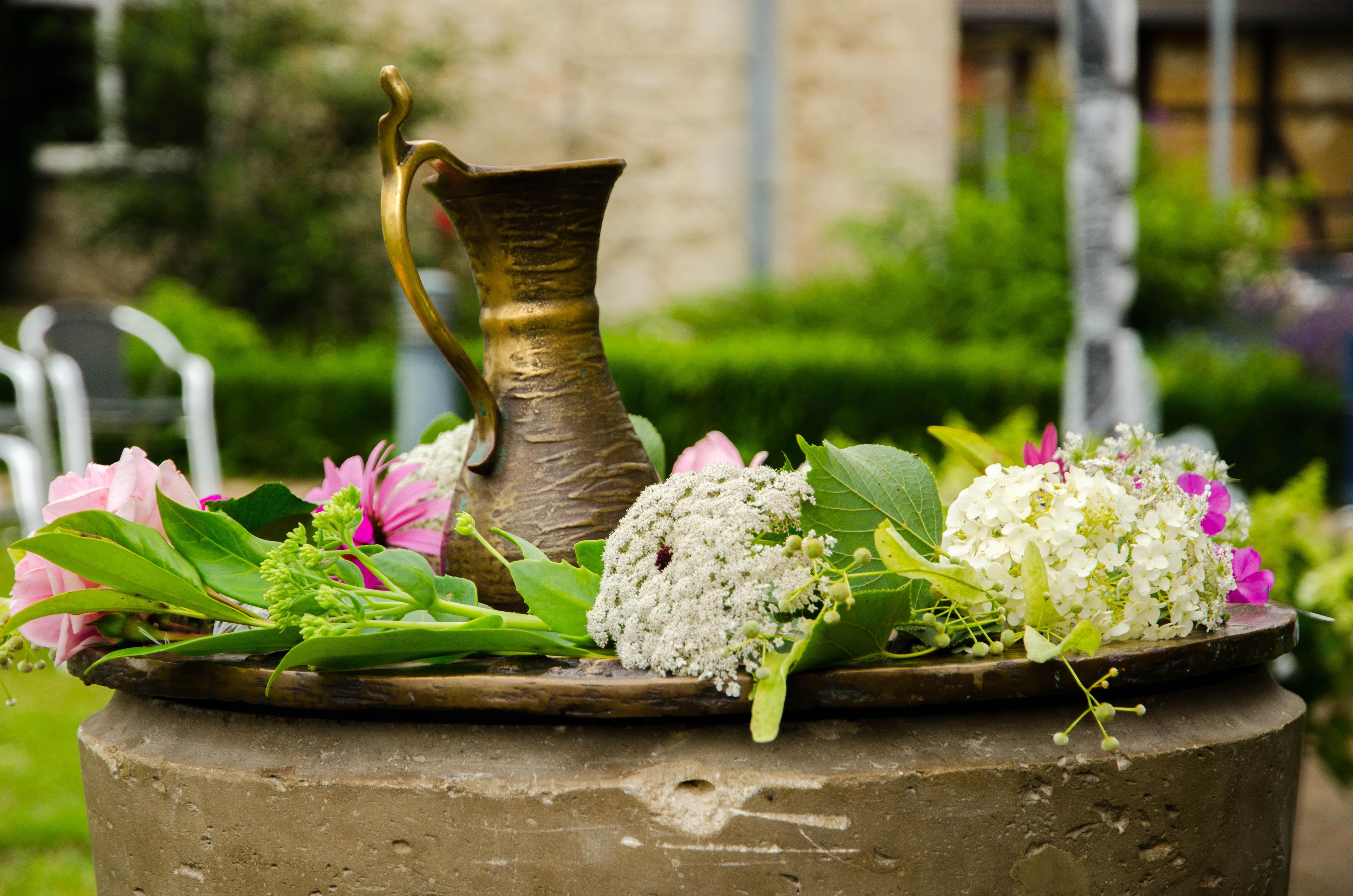 Mit Blumen geschmücktes Taufbecken im Kirchgarten