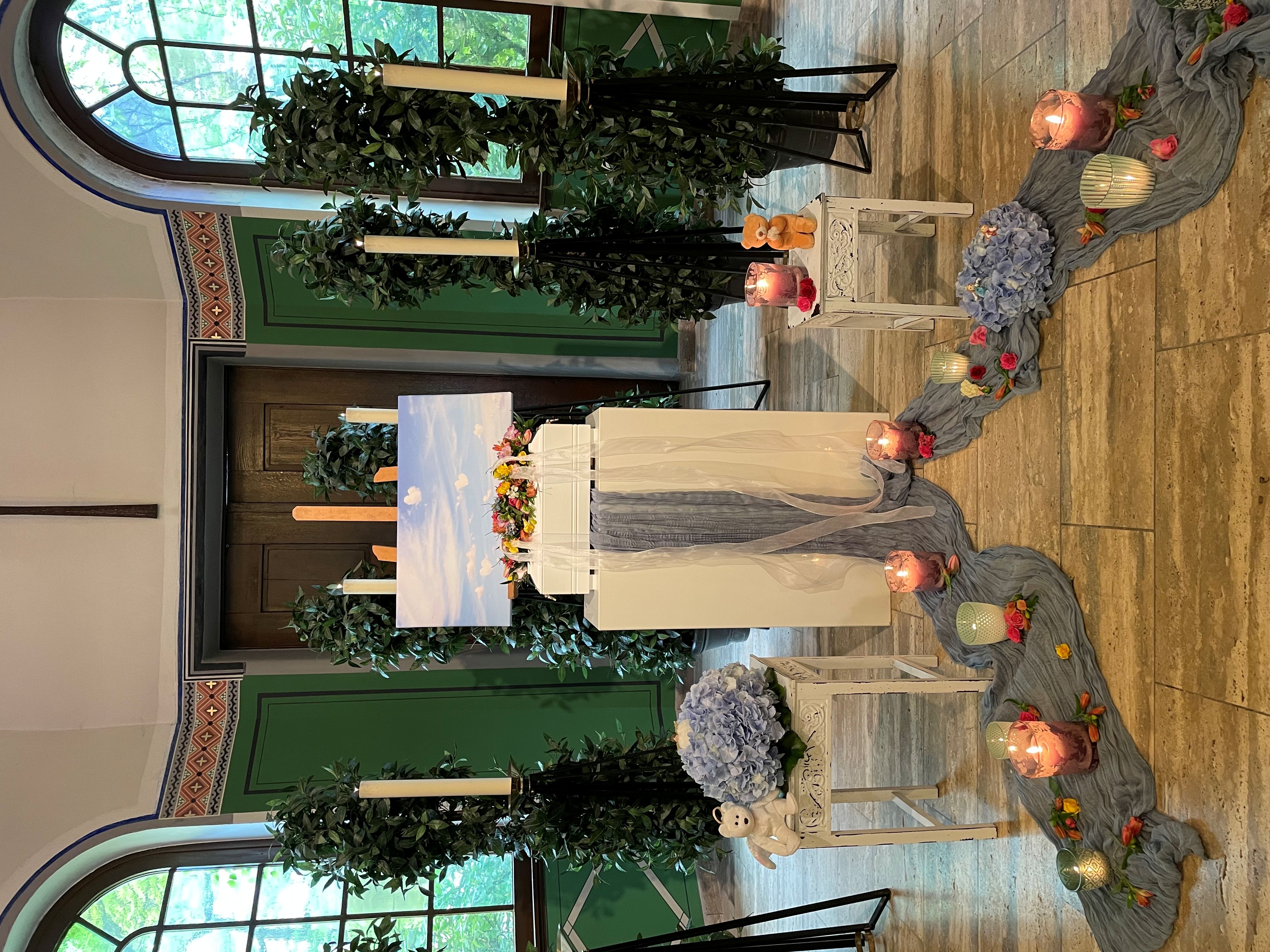 Das Bild zeigt den Altar einer Kirche mit Kerzen auf dem Boden davor. Der Altarraum ist für einen Gedenkgottesdienst hergerichtet