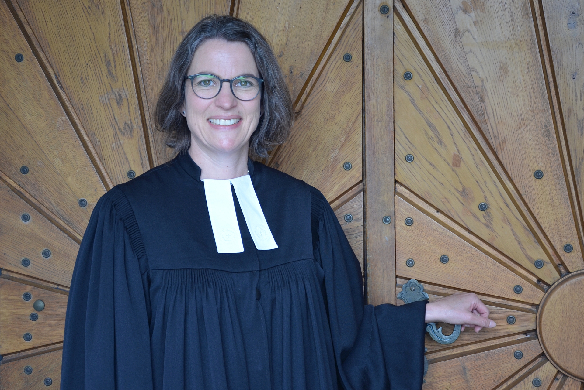 An ihrem neuen Arbeitsplatz angekommen: Pfarrerin Dr. Anke Mühling an der Eingangstür der Urberacher Petruskirche
