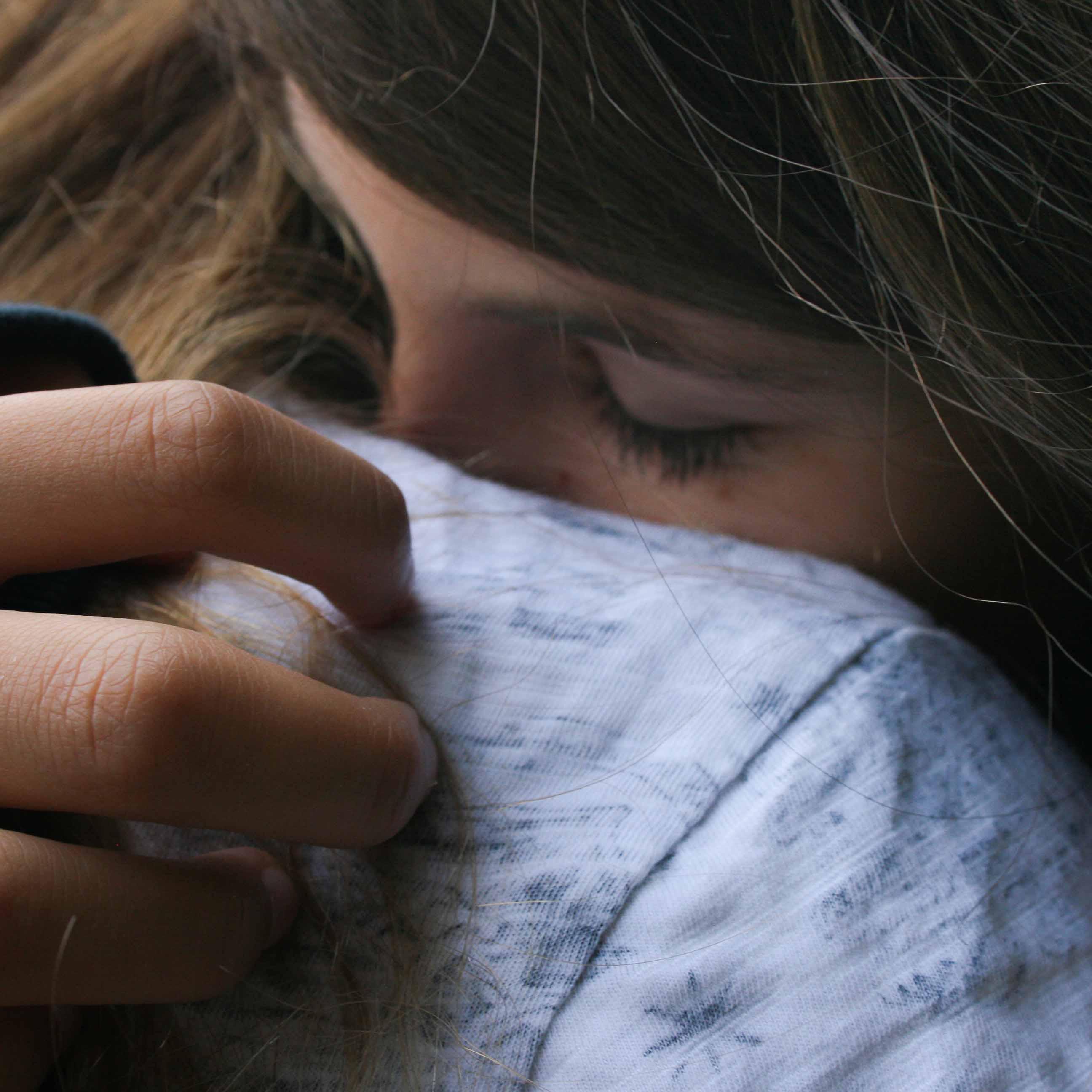 Eine Frau lehnt an der Schulter einer anderen Frau.