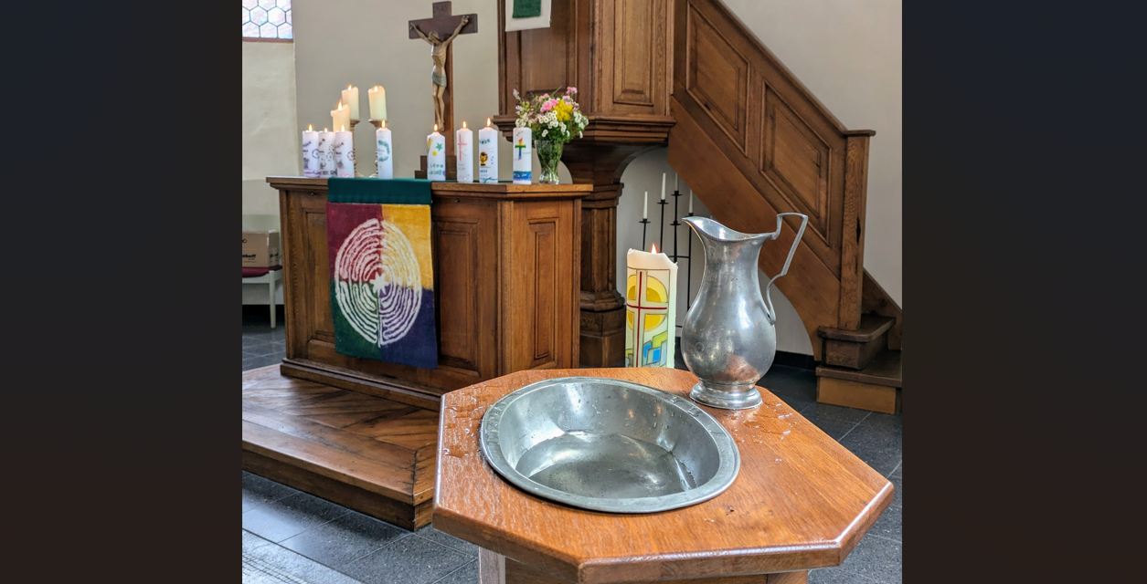 Das Bild zeigt einen Altar und ein Taufbecken