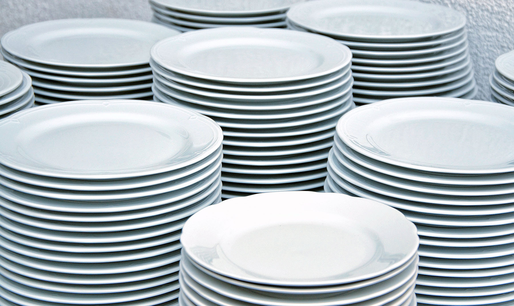 mehere Stapel flacher weißer Teller