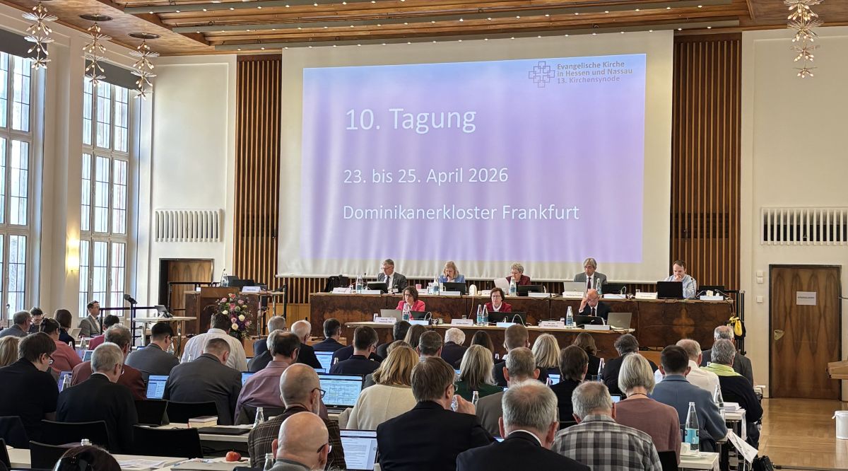 Viele Menschen bei einer Sitzung der EKHN-Synode in Frankfurt. Vorne ist eine Leinwand und ein Podium aufgebaut.
