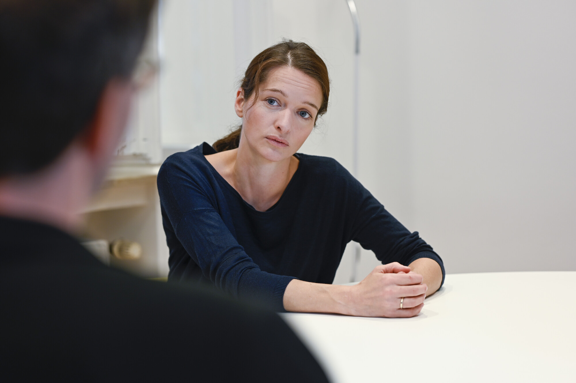 Seelsorge Eine Frau hört ihrem Gegenüber aufmerksam in einem persönlichen Gespräch zu.