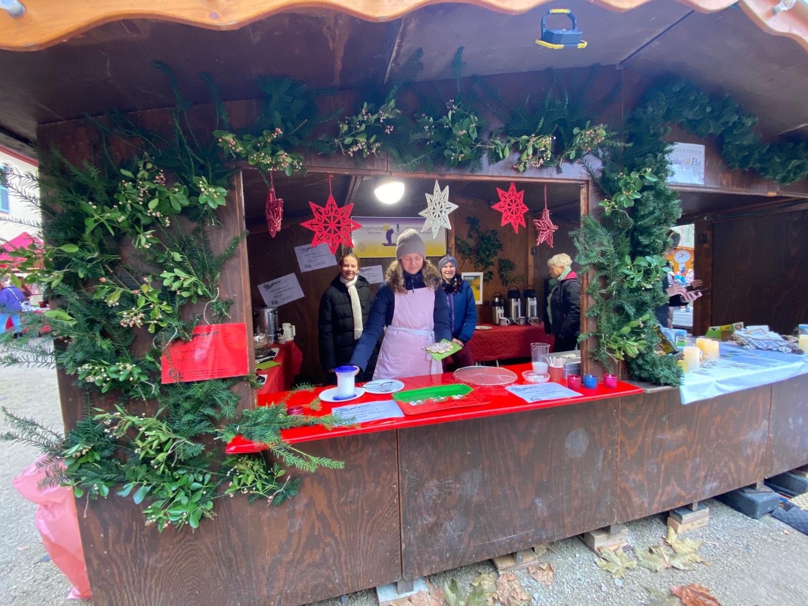 3 Personen stehen in eine Bude auf dem Weihnachtsmarkt in Herrnsheim und verkaufen Waffeln