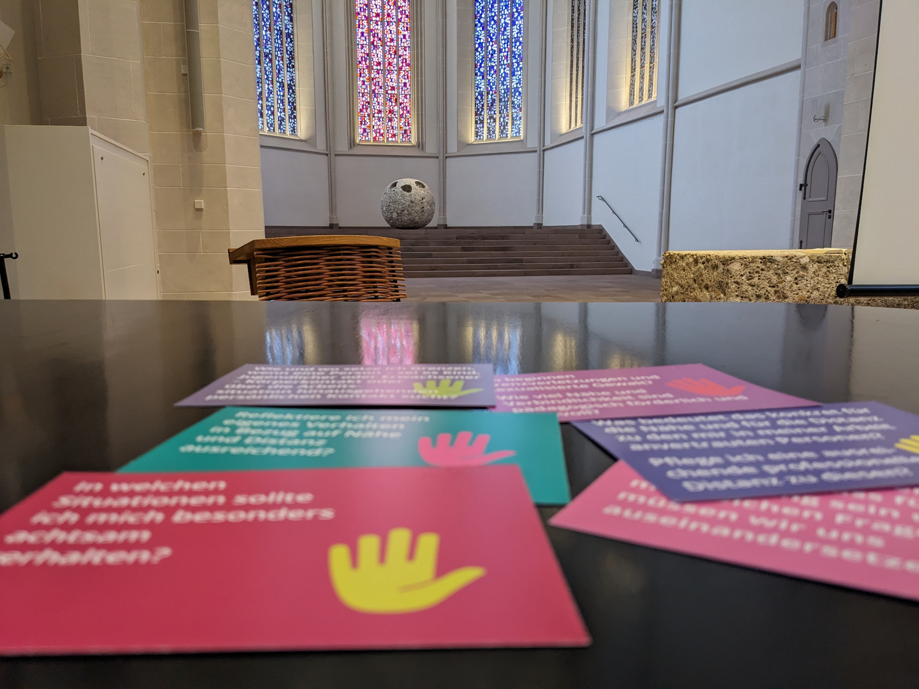 Diskussionskarten in bunter Farbe liegen auf dem Flügel. Im Hintergrund sieht man den Altar der Nikolaikirche.