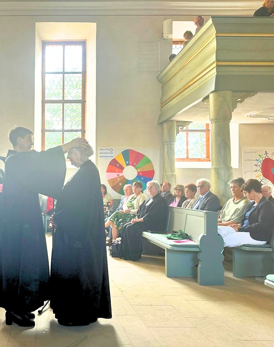 Pröpstin Sabine Bertram-Schäfer steht neben Pfarrerin Andrea Wiemer und spricht ihr während der Entpflichtung im Gottesdienst den Segen zu.