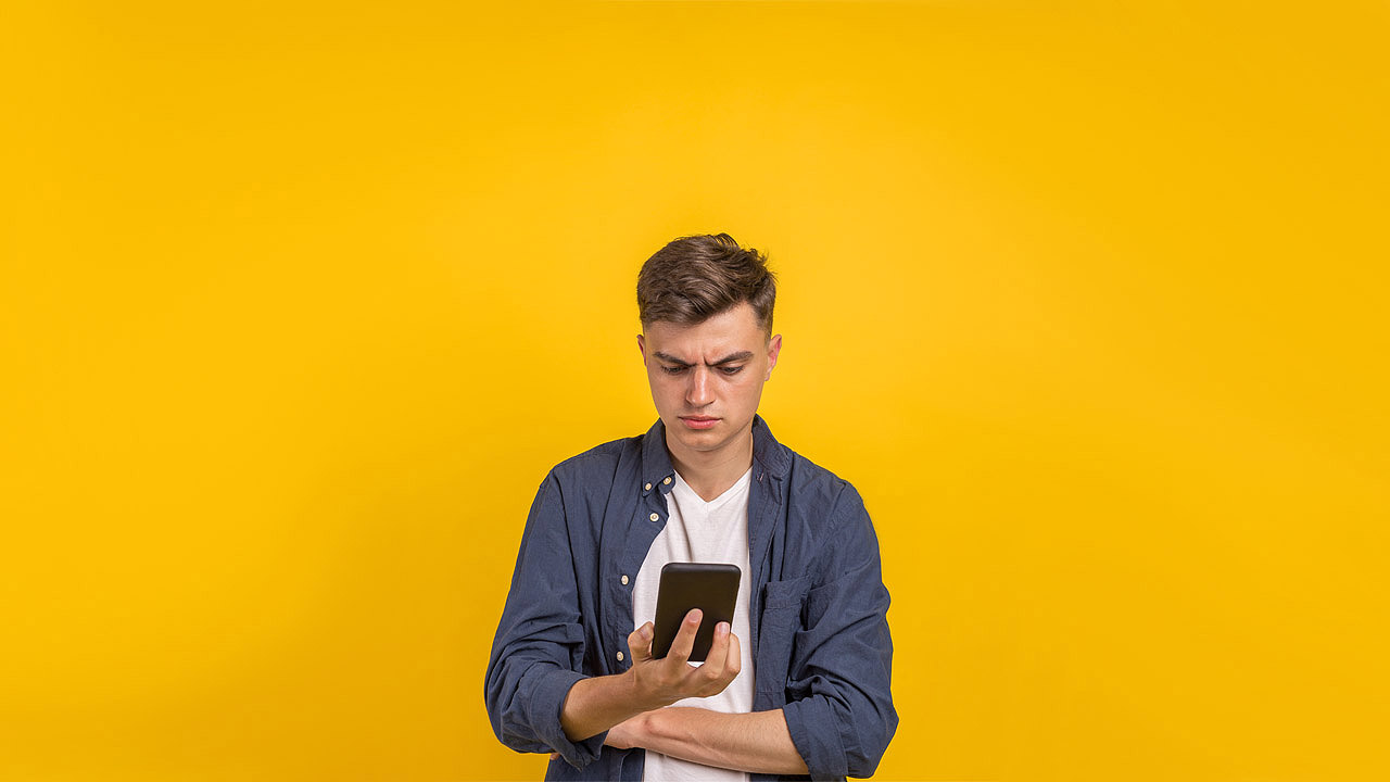 Ein junger Mann checkt die Nachrichten auf seinem Smartphone