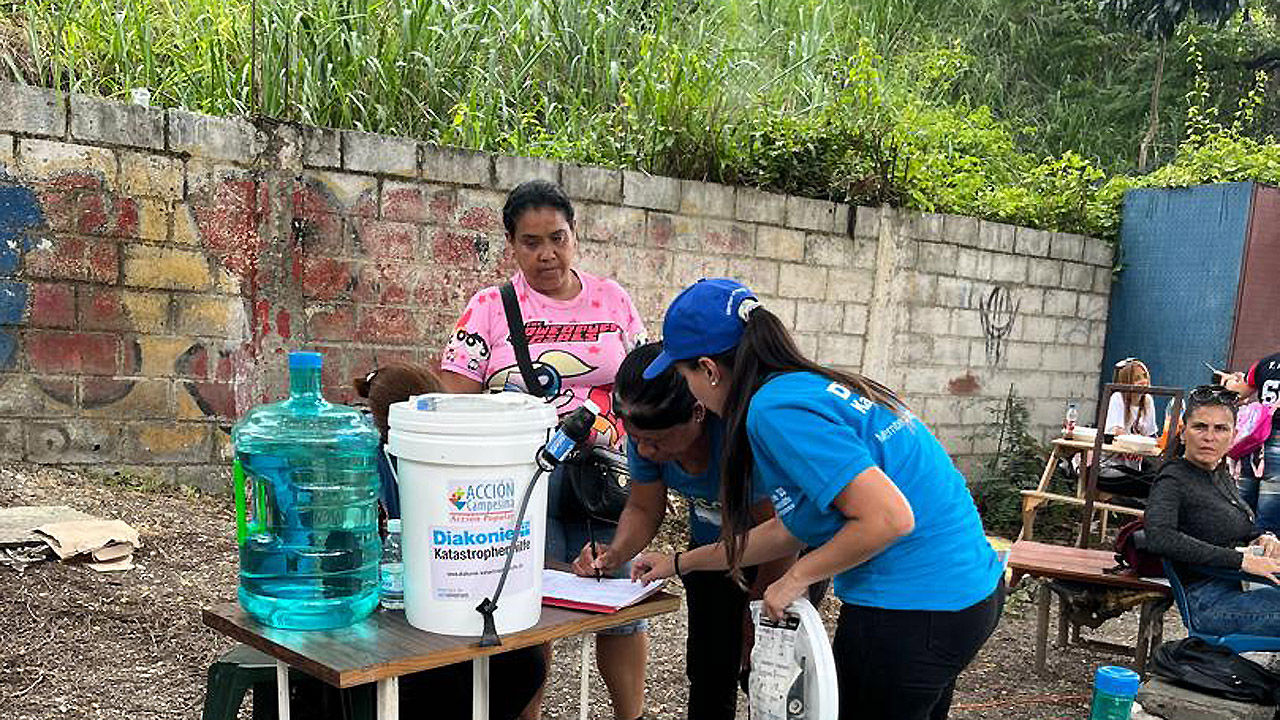 Menschen mit Kanistern und anderen Materialen beschäftigen sich mit Wasseraufbereitung