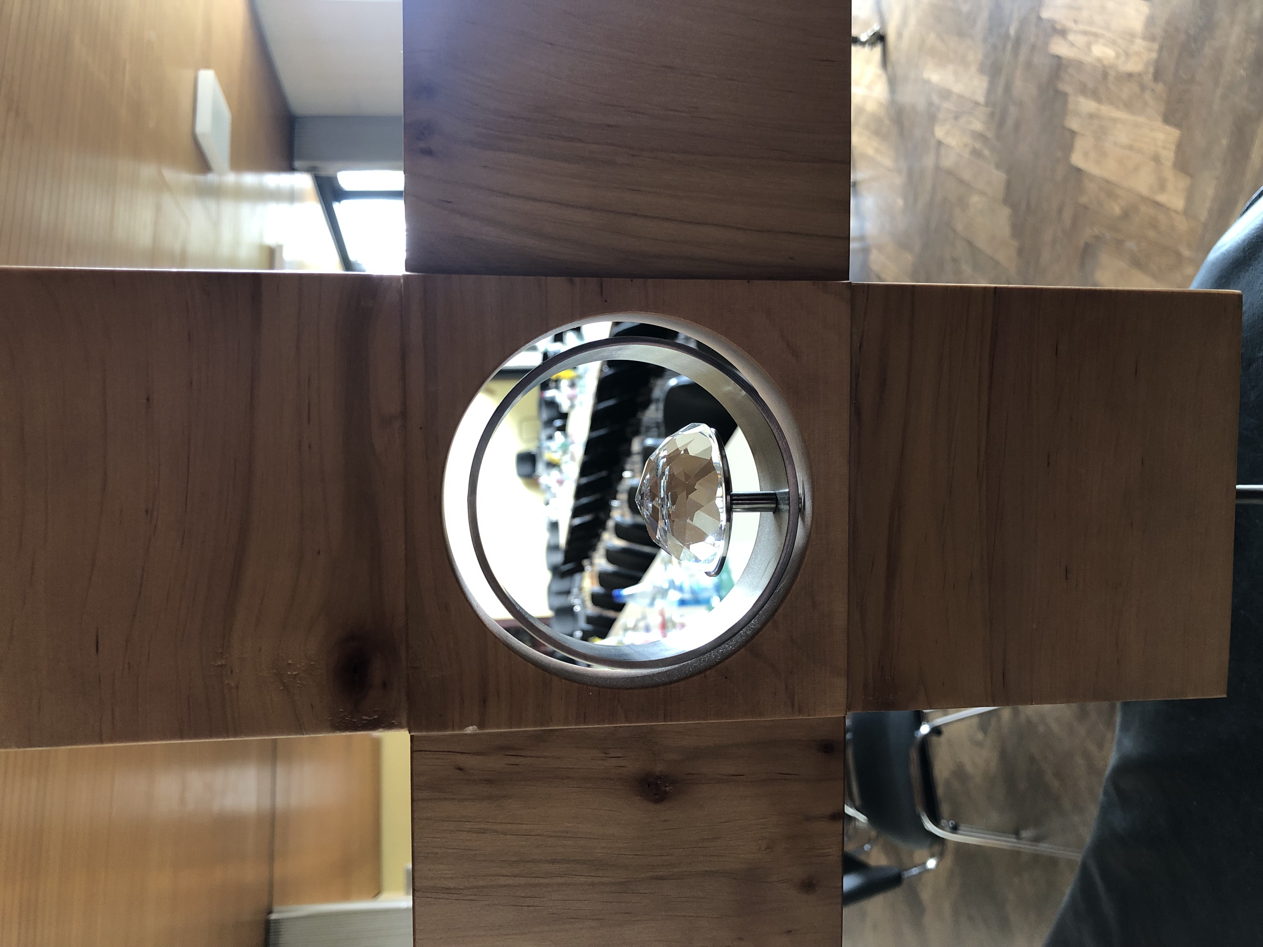 Blick durch ein Loch in einem Holzkreuz auf den Tagungssaal im Gemeindehaus Steinbach