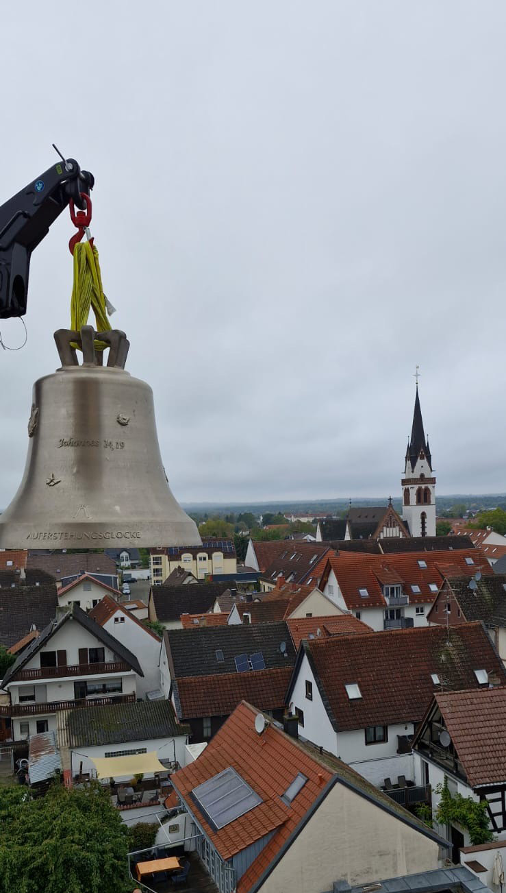 Glocke und Kran Die neuen Groß-Zimmerner Glocken wurden mit einem Kran in den Glockenturm gehoben. Im Hintergrund sieht man die katholische Kirche-