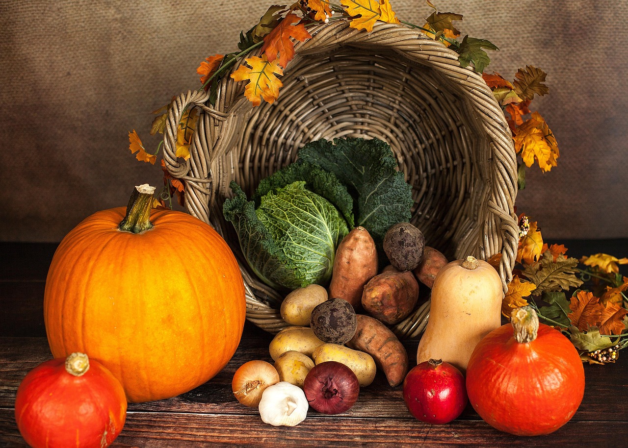 Gefüllter Weidekorb mit herbstlichem Obst und Gemüse