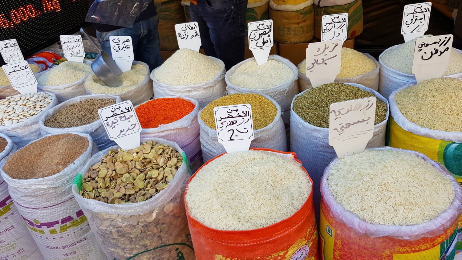 Markt mit verschieden farbigen Säcken Reis, Linsen und Obst 