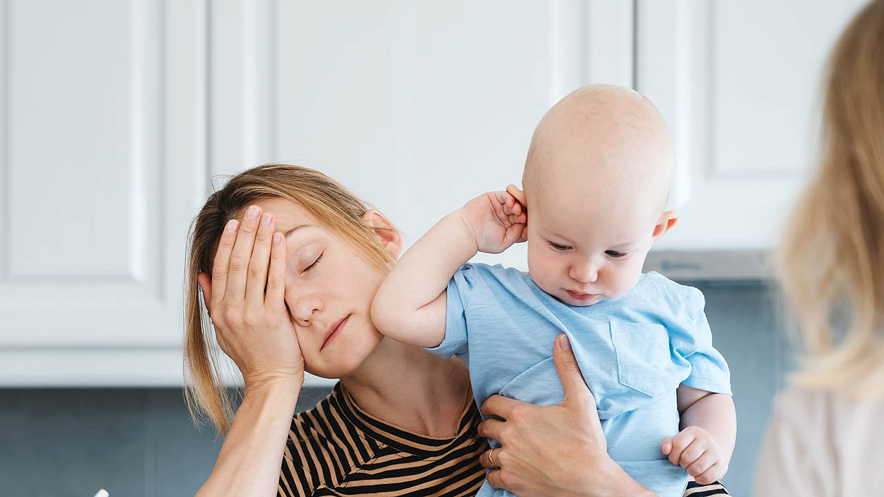 Erschöpfte Mutter mit Baby