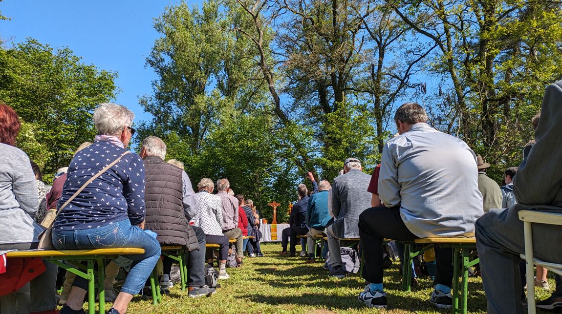 Das Bild zeigt Personen beim Gottesdienst an der Papiermühle.