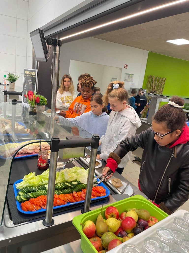 Schülerinnen und Schüler bei der Essensausgabe.