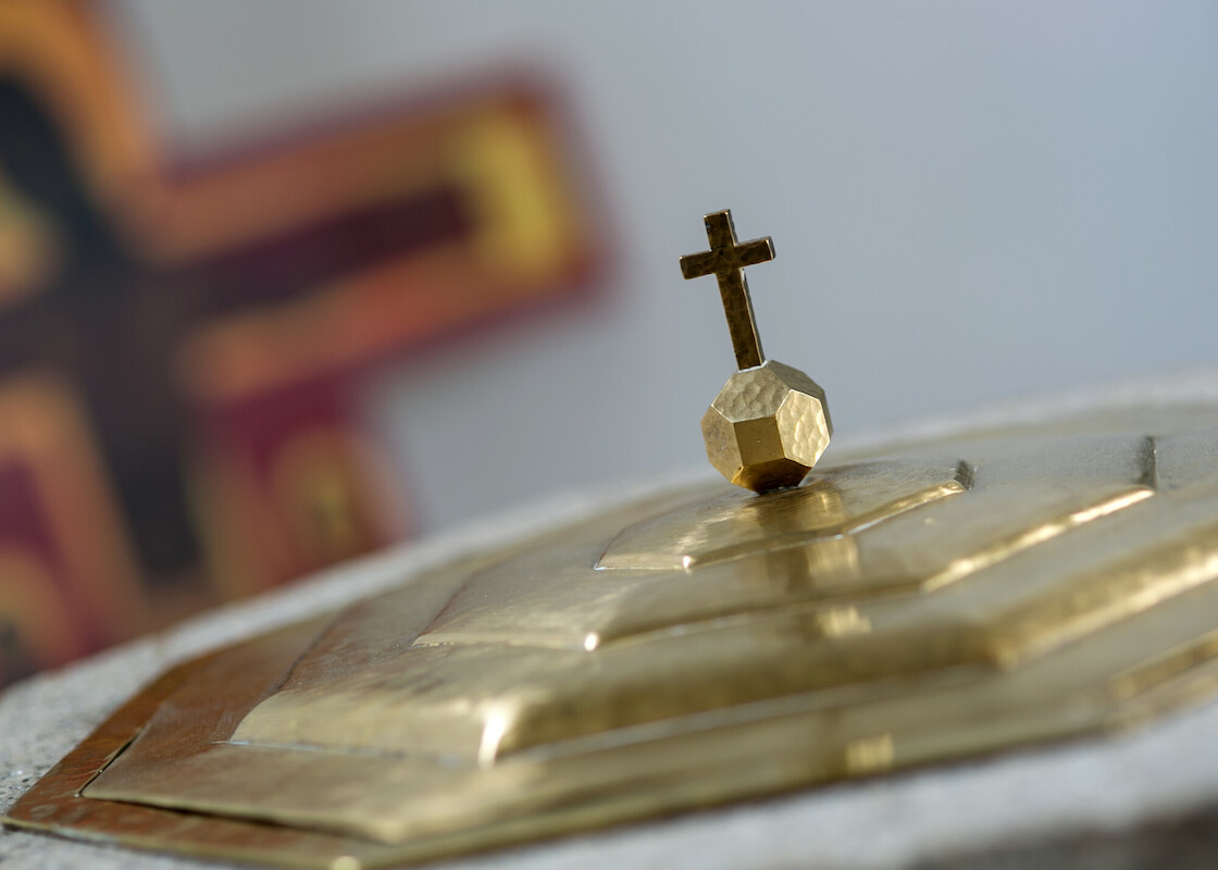 Im Hintergrund unscharf ein Taize-Kreuz