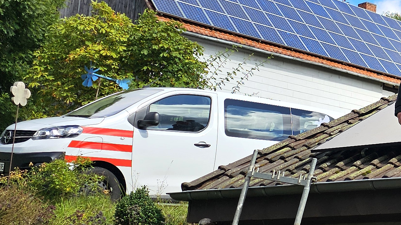 Ein weißer Klein-Bus mit roten Streifen
