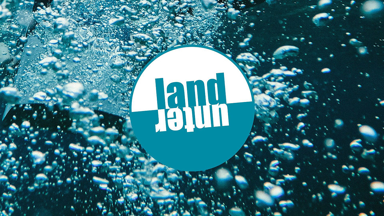 Blasen im Wasser, in der Mitte das Wort "Landunter"