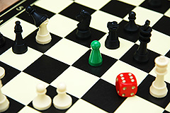 Schachbrett, auf dem sich unterschiedliche Spielfiguren tummeln