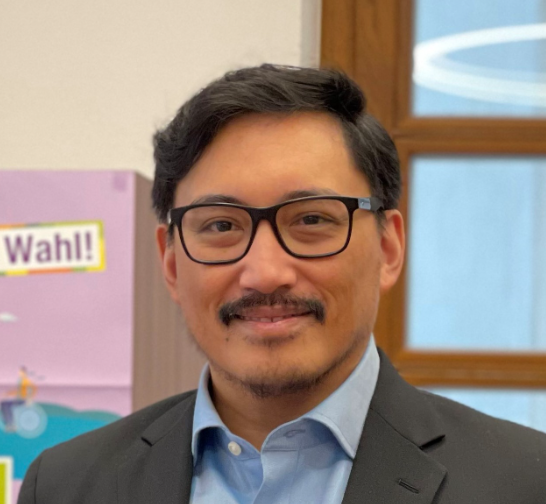 Portraitaufnahme mit Banner der KV-Wahl im Hintergrund