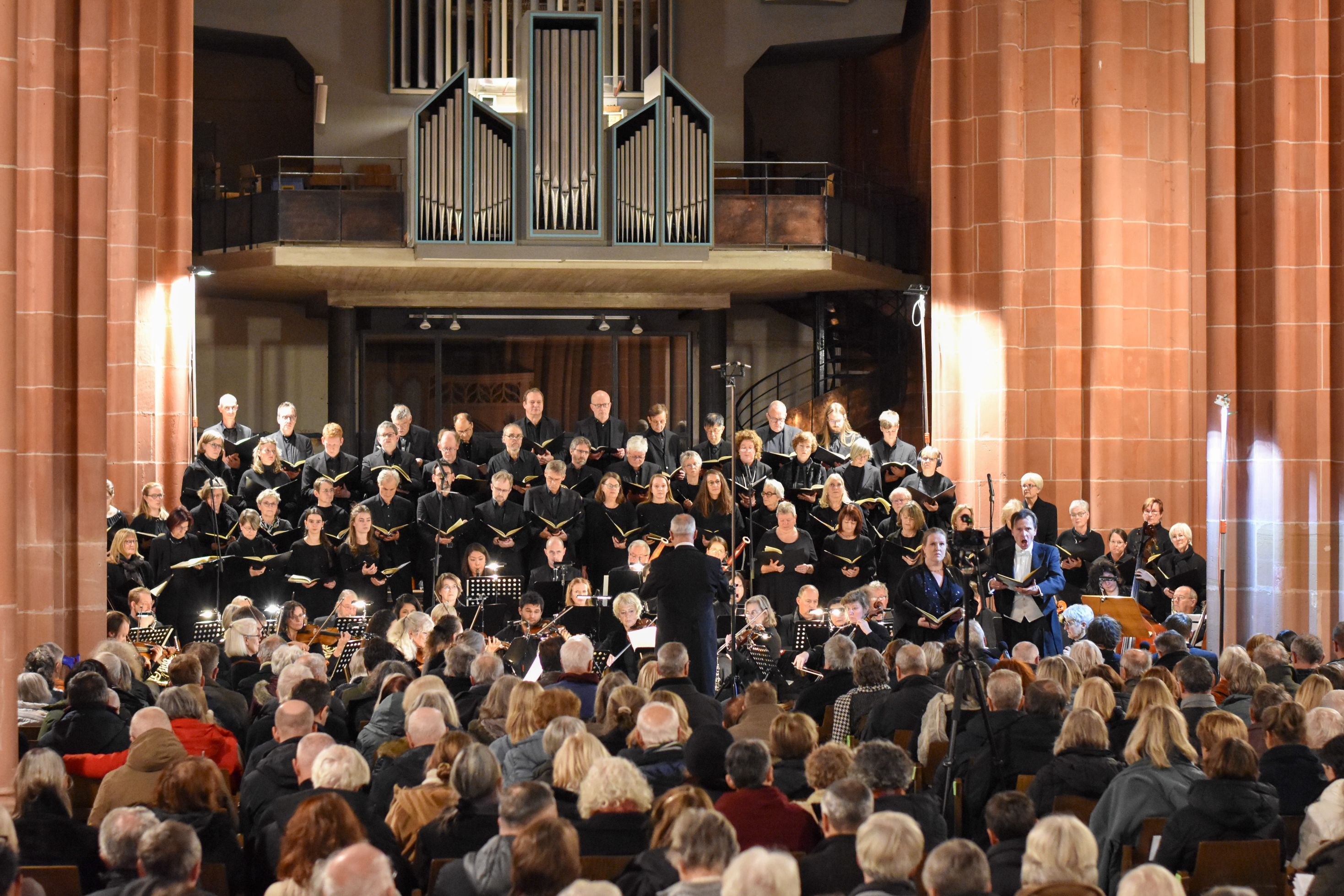 Bild eines Chores mit Orchester und Solisten in einer Kirche.