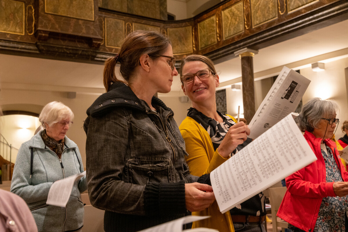Frauen mit Noten in ihren Händen singend in der Kirche 