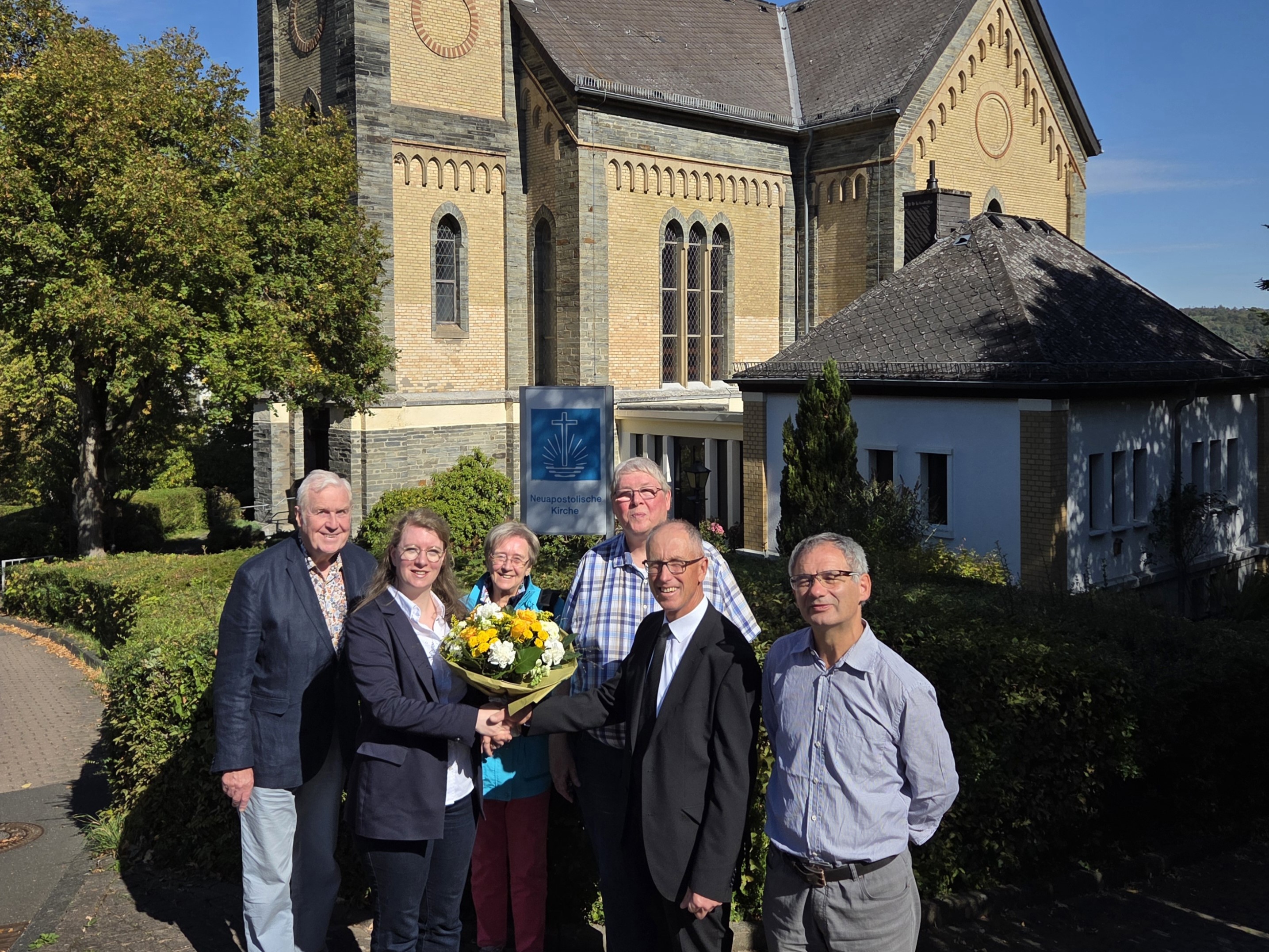 Vertreter der Mitgliedsgemeinden der ACK Bad Schwalbach posieren vor der vor der Neuapostolischen Kirche. Von links nach rechts: Klaus-Peter Hüllen, Pfarrerin Ann-Sophie Huppers (Vorsitzende, ACK Bad Schwalbach), Angelika Hüllen, Thomas Millack, Gerald Götte (Vorsteher der Neuapostolischen Kirchengemeinde Bad Schwalbach), Diakon Kristof Windolf.