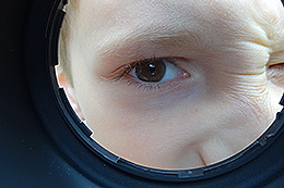 Kinderblick durch ein rundes Loch.