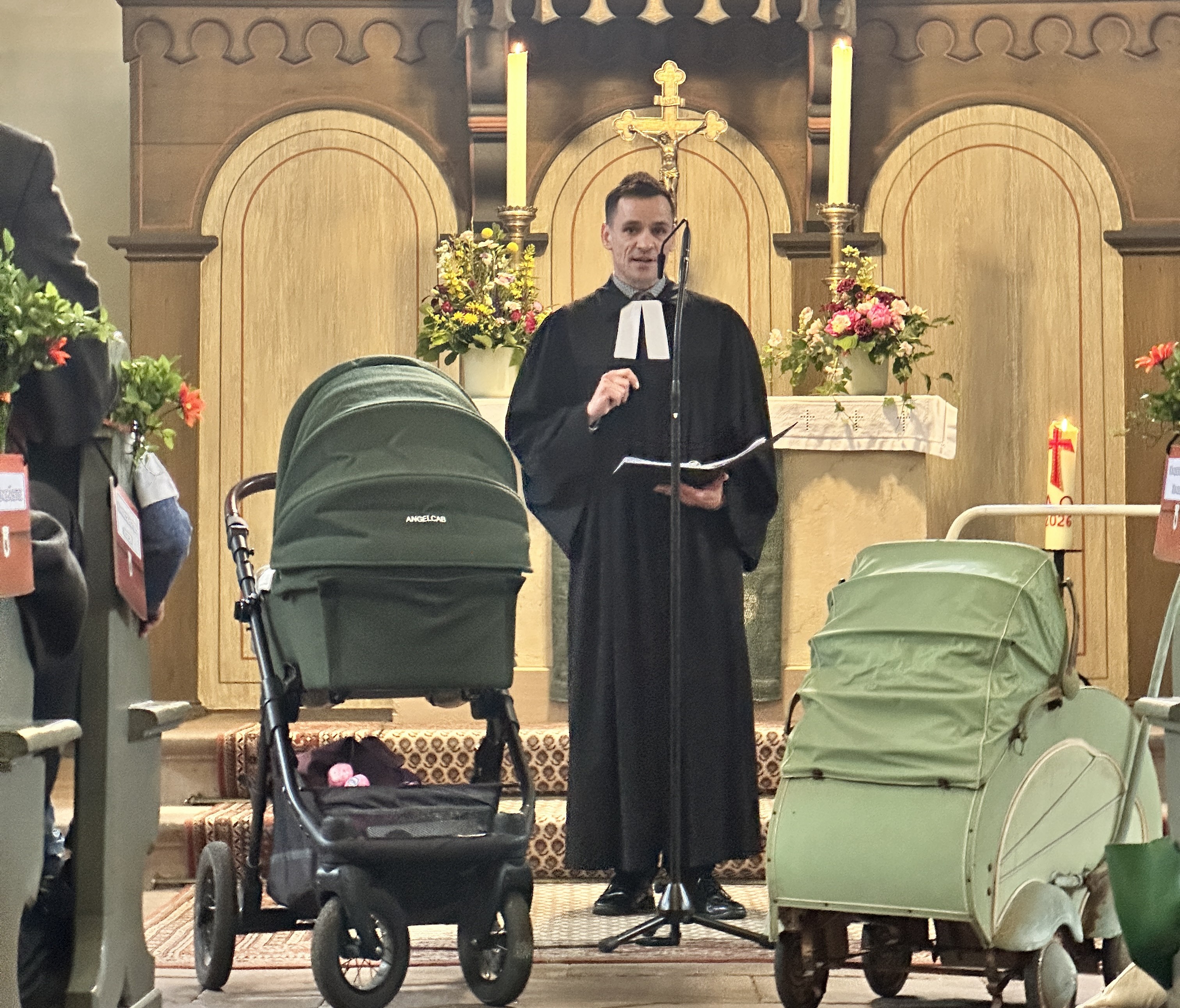 Pfarrer Daniel Meyer steht zwischen zwei Kinderwagen.