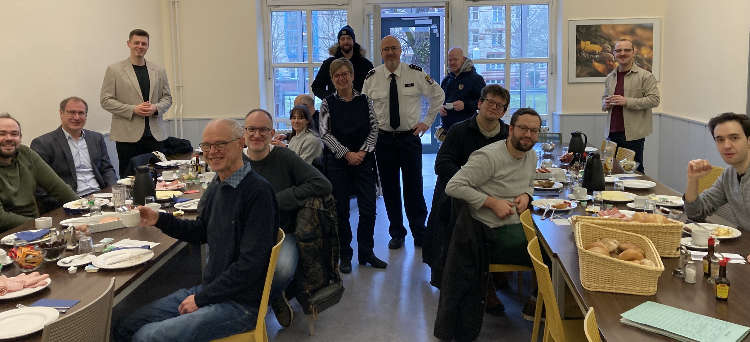 Die Musiker sitzen an zwei Tischen, in der Mitte steht die frühere Pfarrerin mit einigen Personen.